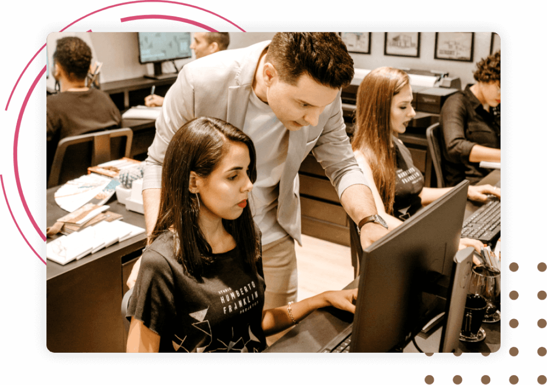 Teacher showing something on the computer screen to a student